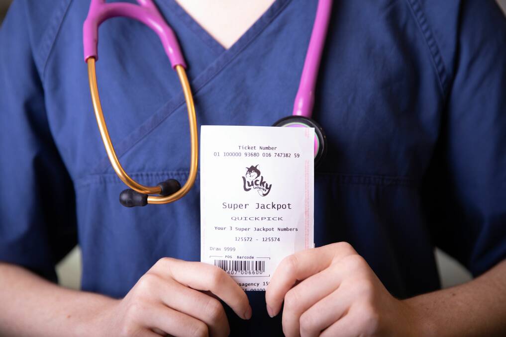 LOTTO: A person wearing medical scrubs holding a lottery ticket. Picture: Supplied